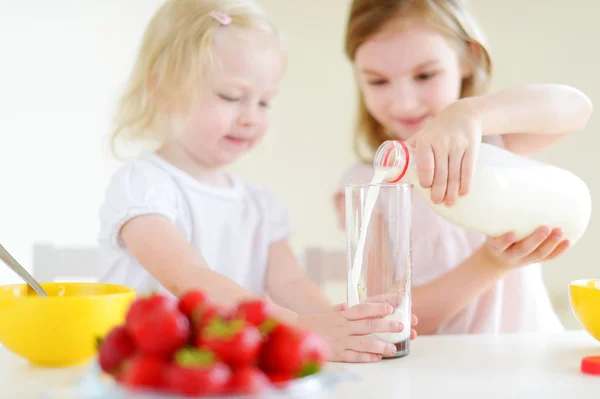 Cute little sisters eating cereal — Stock Photo, Image