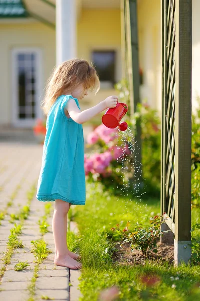 Meisje water geven bloemen — Stockfoto
