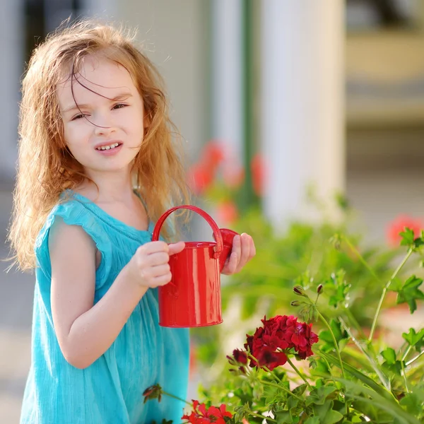 Pequena menina regando flores — Fotografia de Stock
