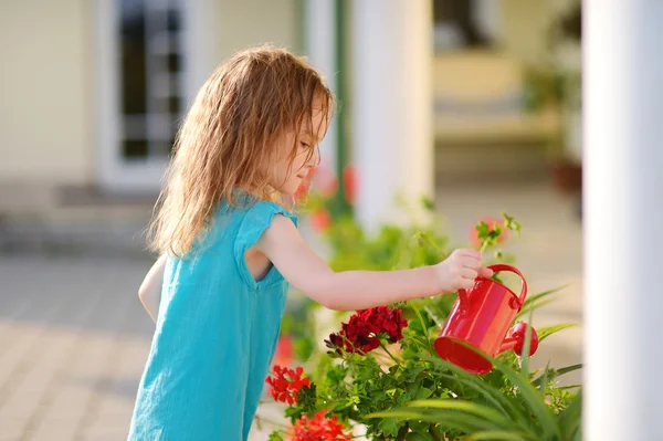 Malá dívka zalévání květiny — Stock fotografie