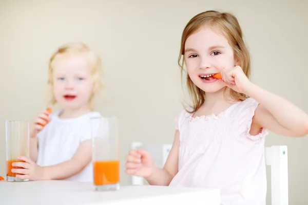 Lilla systrar äta morötter — Stockfoto