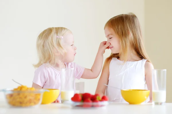 Söta lilla systrar äta spannmål — Stockfoto
