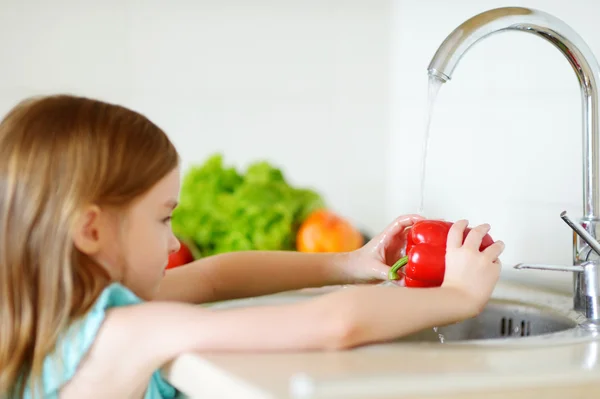 Niña lavando verduras — Foto de Stock