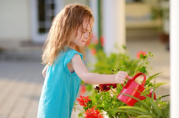 Meisje water geven bloemen — Stockfoto