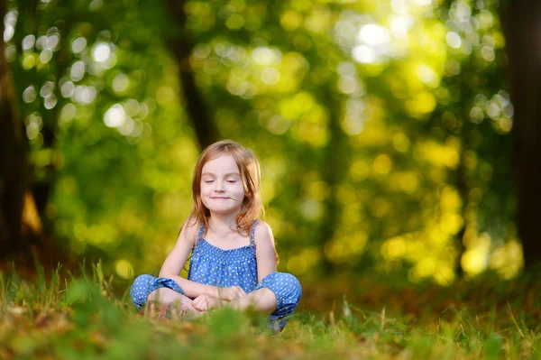 Söt liten flicka sitter på gräset — Stockfoto