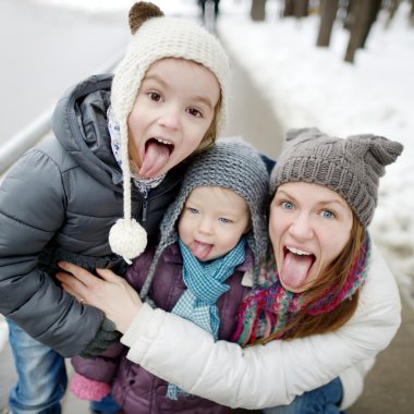 Mother and daughters showing tongues clipart