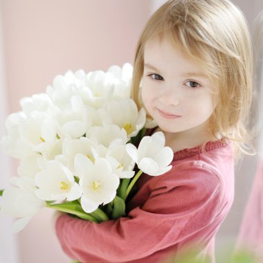 Lale ile gülümseyen küçük kız