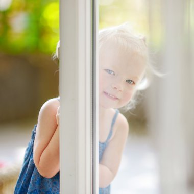 Little toddler girl peeking into a window clipart