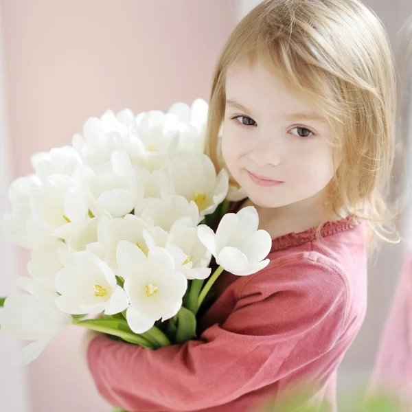 Sorridente bambina con i tulipani — Foto Stock