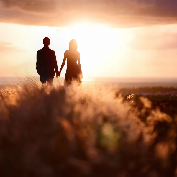 Jovem casal desfrutando do pôr do sol — Fotografia de Stock