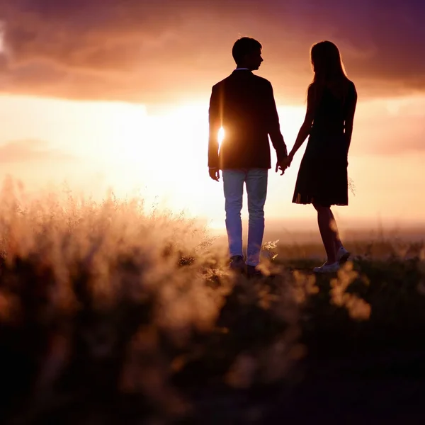 Jovem casal desfrutando do pôr do sol — Fotografia de Stock