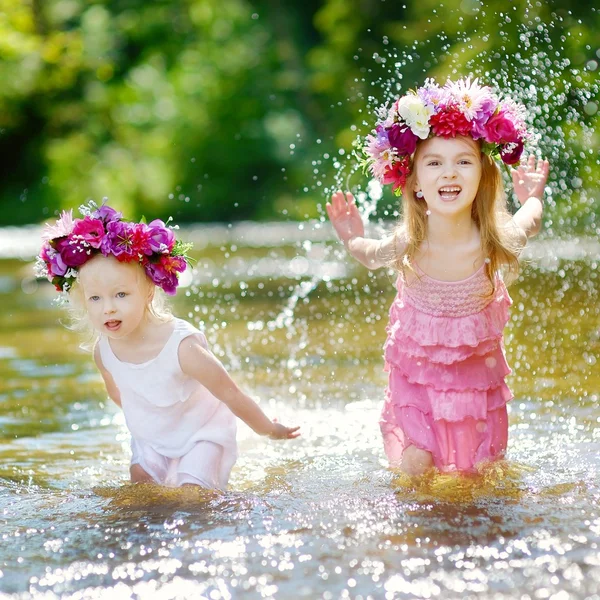 Little sisters wearing wreath in river — Stock Photo, Image