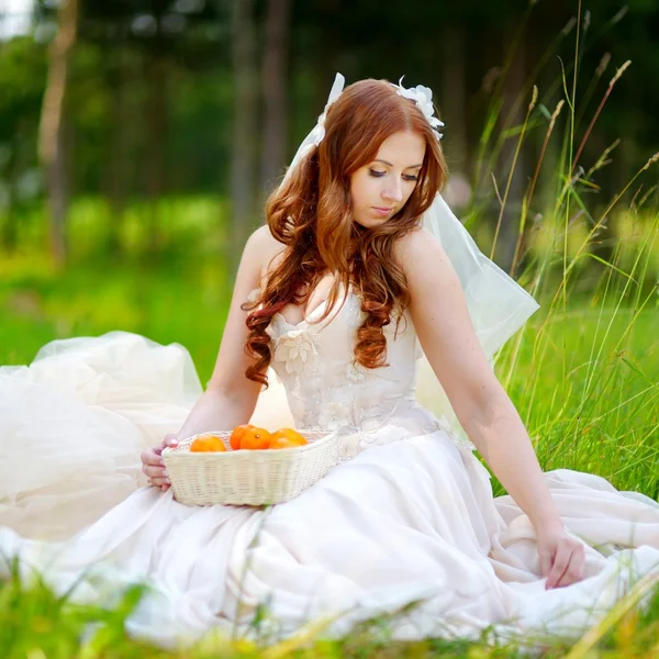 Молодая невеста сидит на траве — стоковое фото