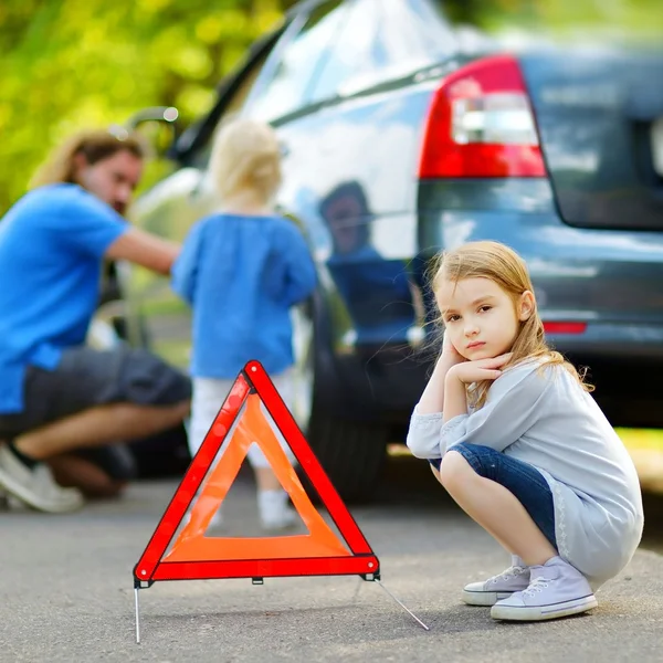 Pai e filhas mudando roda do carro — Fotografia de Stock