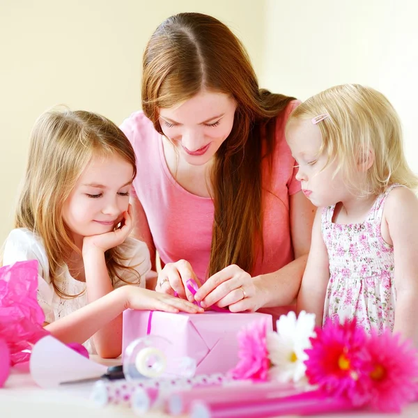 Madre e hijas envolviendo regalo — Foto de Stock