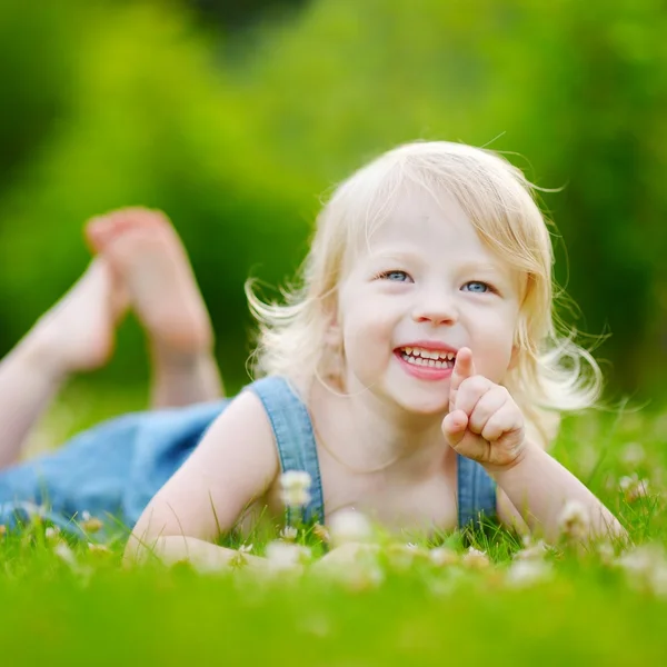 Toddler girl laying in grass — Stock Photo, Image