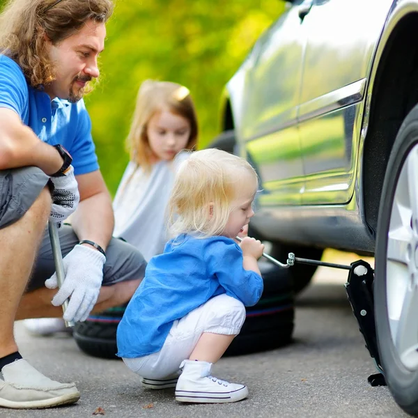 Petite fille aidant père avec la voiture — Photo