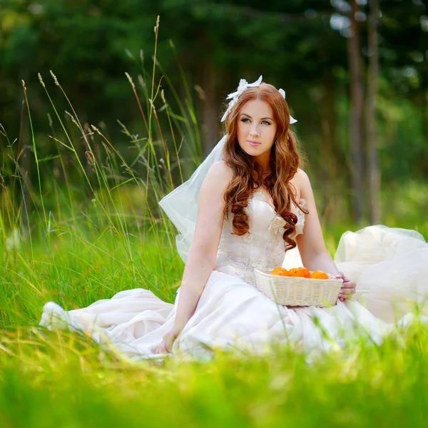 Young bride sitting on a grass — Stock Photo, Image