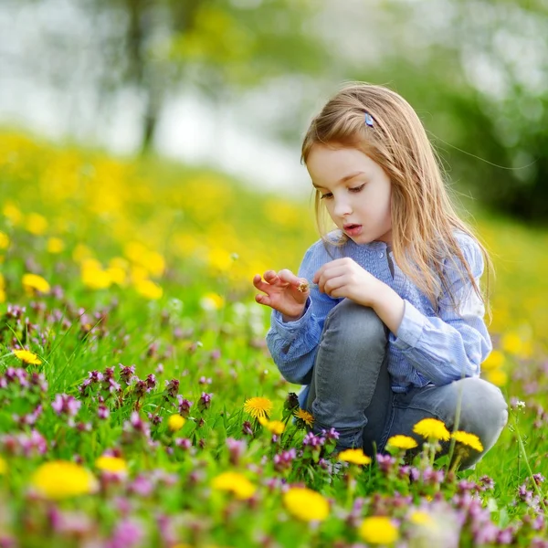 Menina adorável com flores de dente de leão — Fotografia de Stock