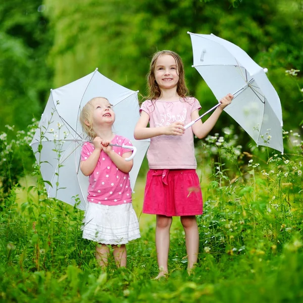 Little sisters with umbrellas — Stock Photo, Image