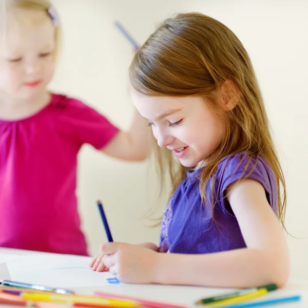 Little sisters drawing with pencils Royalty Free Stock Images