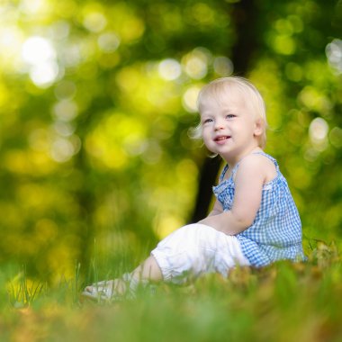 Yeşil çimenlerde oturan kız