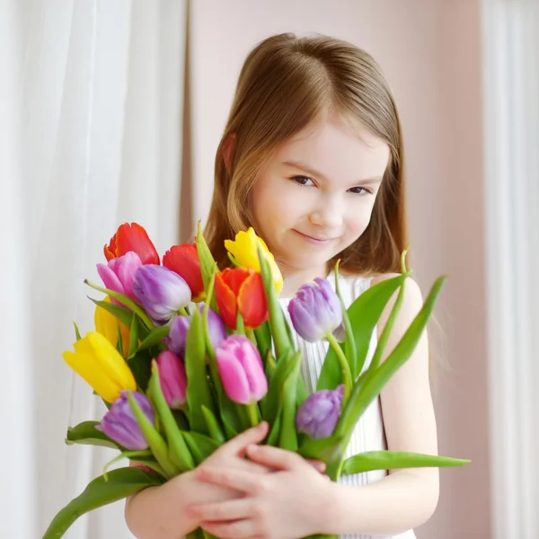 Kleines Mädchen mit bunten Tulpen — Stockfoto