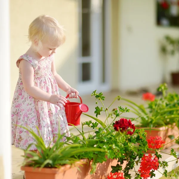 Petite fille arrosant des fleurs dans le jardin — Photo