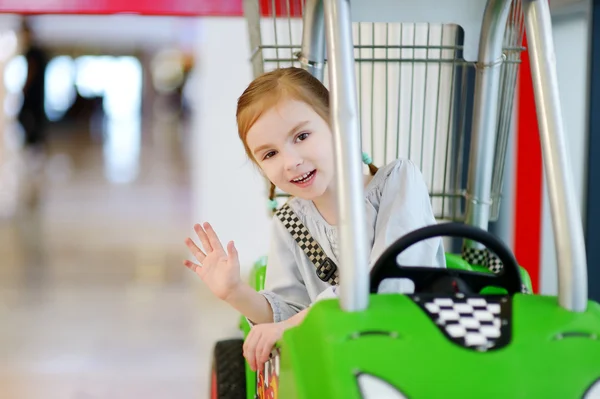 Chica sentada en el carrito de compras —  Fotos de Stock