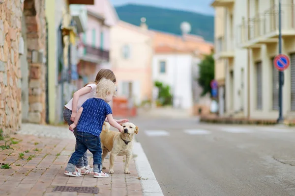 Cute little sisters i pies — Zdjęcie stockowe