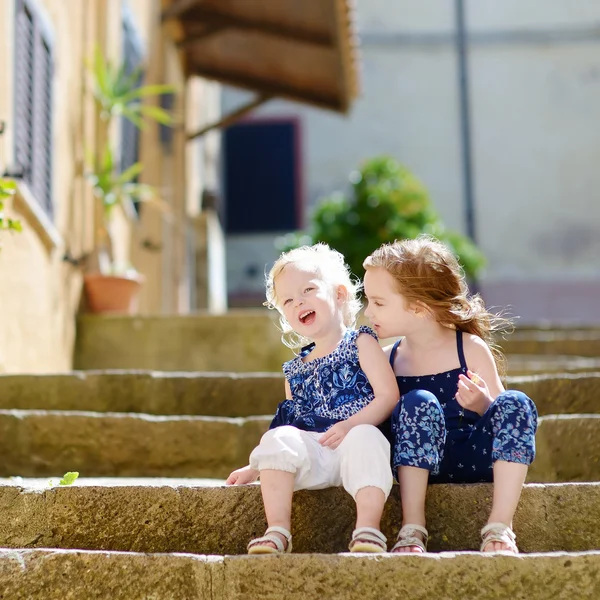 Cute little siostry siedząc na schodach — Zdjęcie stockowe