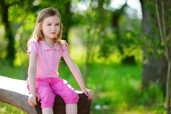 Petite fille assise sur un banc — Photo