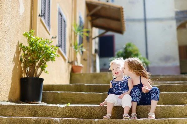 Cute little siostry siedząc na schodach — Zdjęcie stockowe