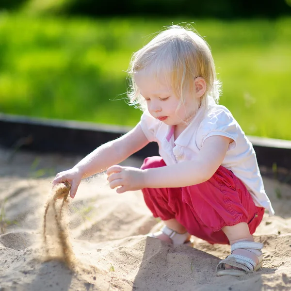 Játszik a homokozóban kislány — Stock Fotó