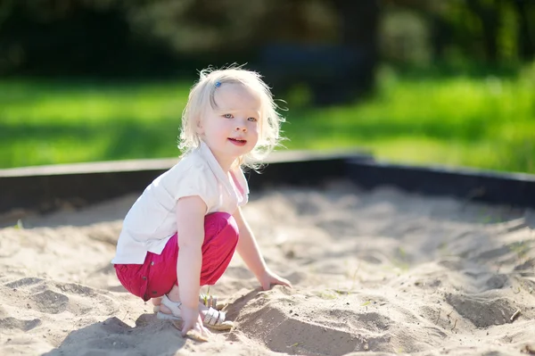 Liten flicka som leker i sandlådan — Stockfoto