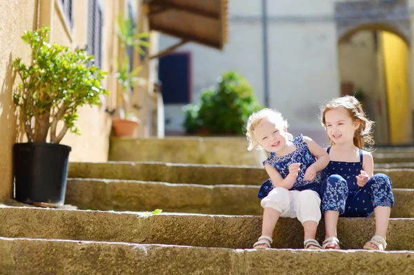 Söta lilla systrar sitter på trappan — Stockfoto