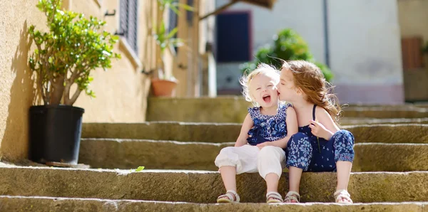 Söta lilla systrar sitter på trappan — Stockfoto