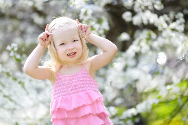 Meisje tijdens de bloei cherry tuin — Stockfoto