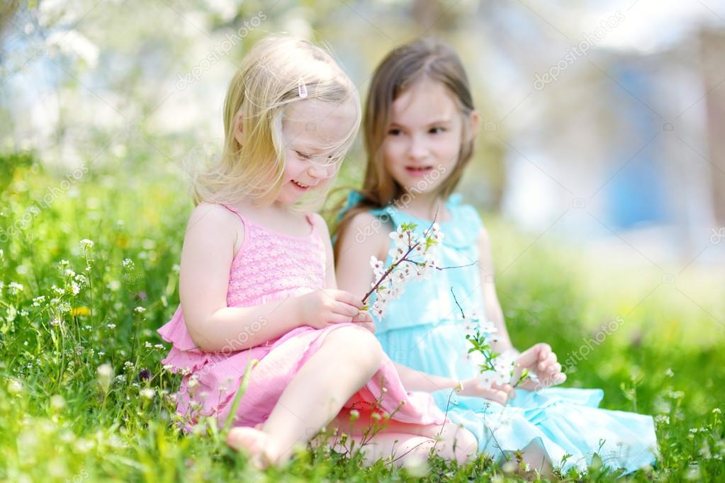 Hermanas en floreciente jardín de cerezos fotografía de stock © MNStudio 71716211 Depositphotos