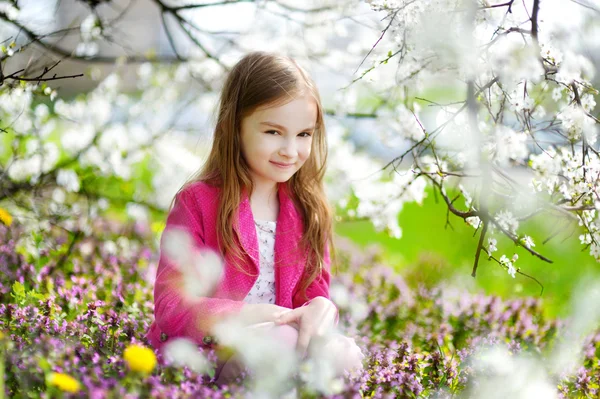 Mała dziewczynka w kwitnących wiśni ogród — Zdjęcie stockowe