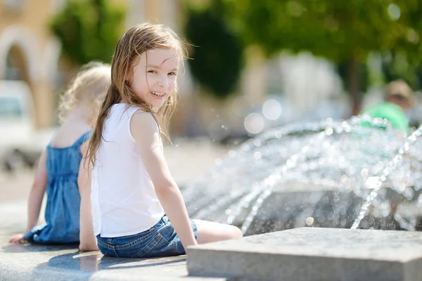 Förskolebarn flickor leker med staden fontän — Stockfoto