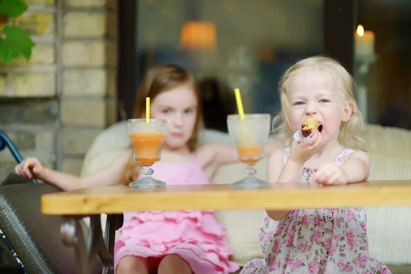 Kleine Schwestern trinken Orangensaft — Stockfoto