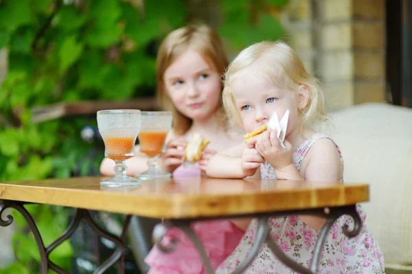 Kleine Schwestern trinken Orangensaft — Stockfoto