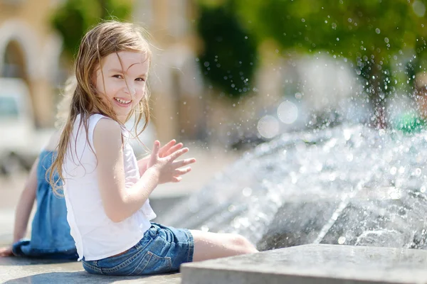 Fille jouer avec une fontaine de la ville — Photo