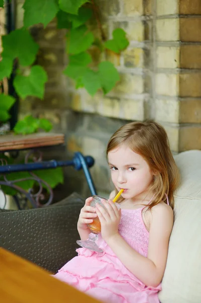 Dívka pije pomerančový džus — Stock fotografie