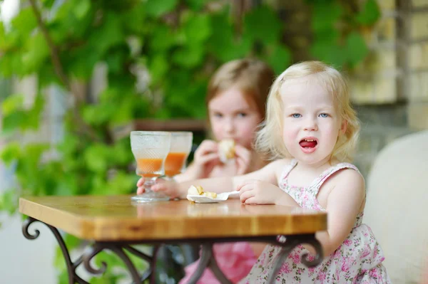 Kleine Schwestern trinken Orangensaft — Stockfoto