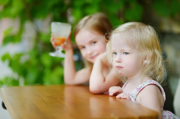 Hermanas bebiendo jugo de naranja — Foto de Stock