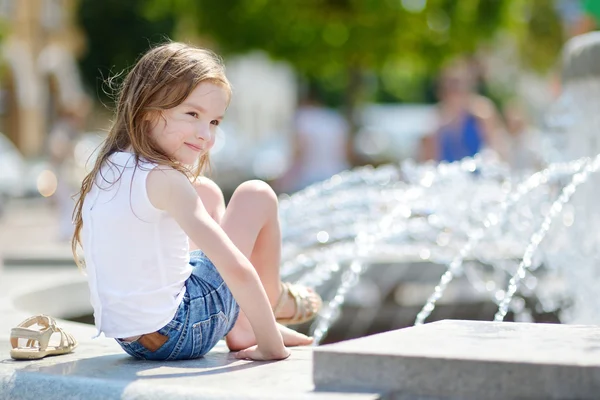 Girl playing with a city fountain — Stock Photo, Image