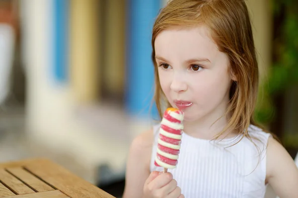 Девушка ест мороженое на открытом воздухе — стоковое фото