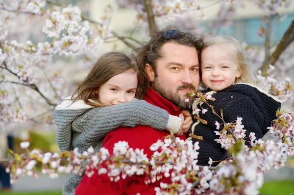 Pai e filhos no jardim florescente — Fotografia de Stock